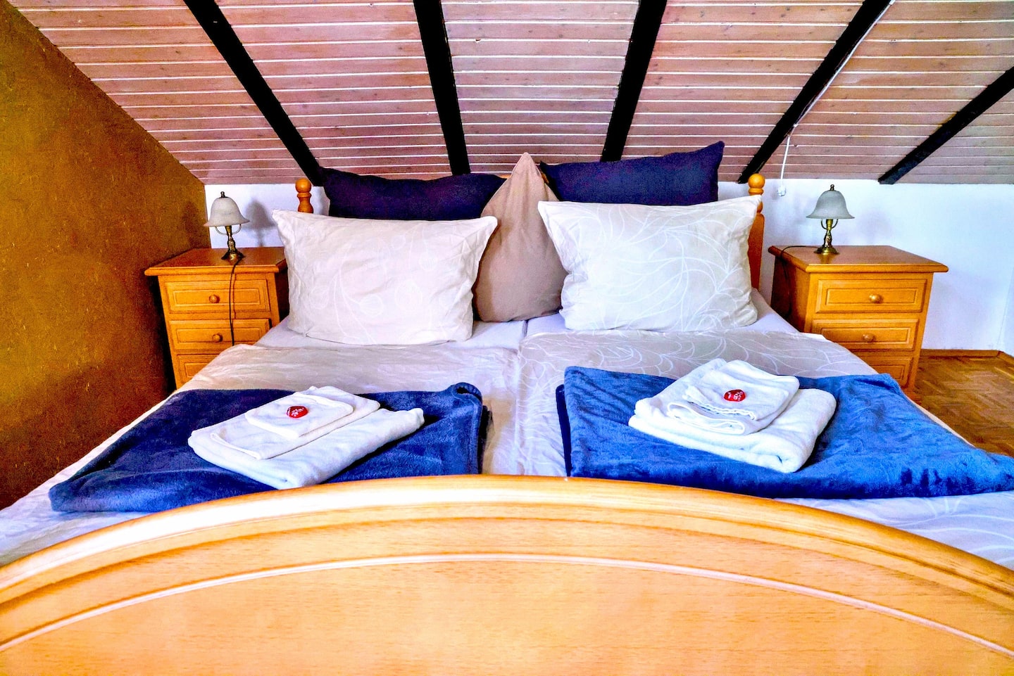 Doppelbett unter sichtbaren Holzbalken